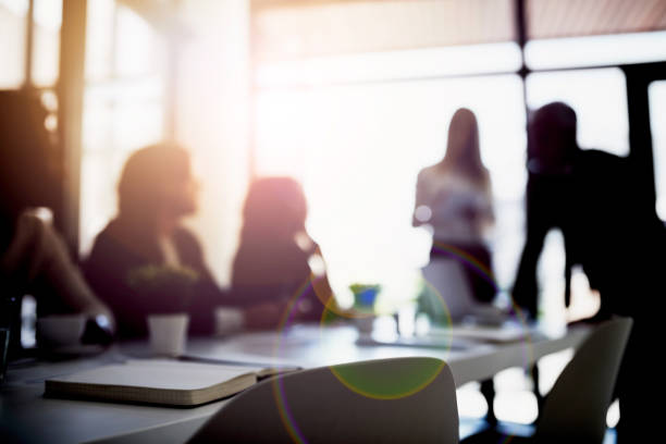 Bringing business into focus Shot of two business colleagues talking together during a meeting in a boardroom obscured face stock pictures, royalty-free photos & images