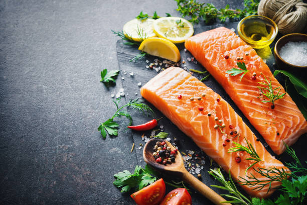 istock Fresh salmon fillet with aromatic herbs, spices and vegetables 680547246