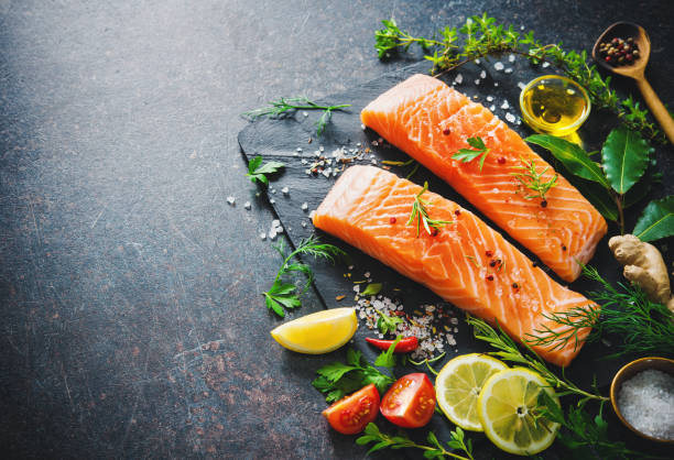 istock Fresh salmon fillet with aromatic herbs, spices and vegetables 680547248