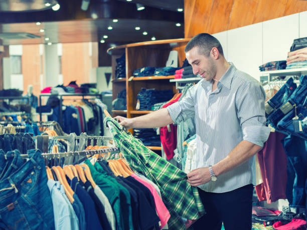 istock Young man choosing suit in clothes store 680547638