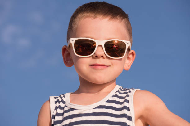 istock cool smiling little boy wearing sunglasses with ocean sunset reflection 680654472