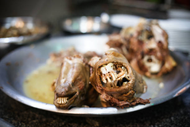 Iranian sheep goat head stew soup, boiled sheep head with teeth steering out in a plate - a bizzar Persian dish (also called Pacha, khash, kalleh, pacheh)