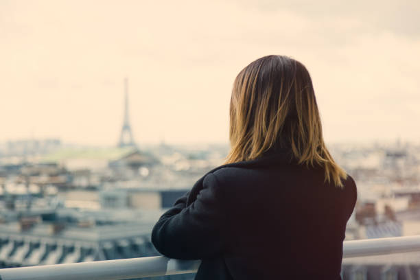 istock young woman looking at Paris 680673276