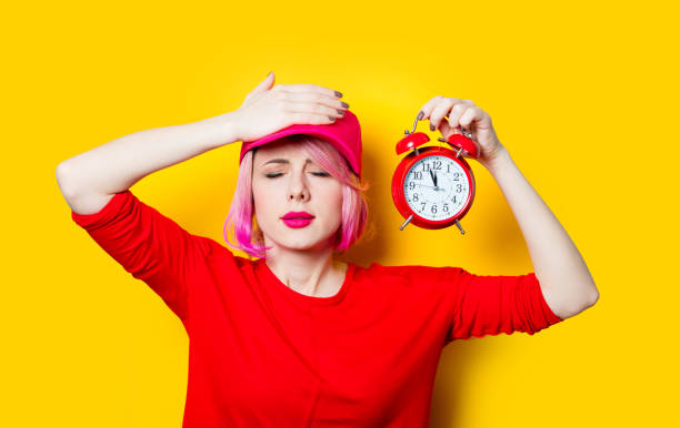 istock young woman with alarm clock 680676612