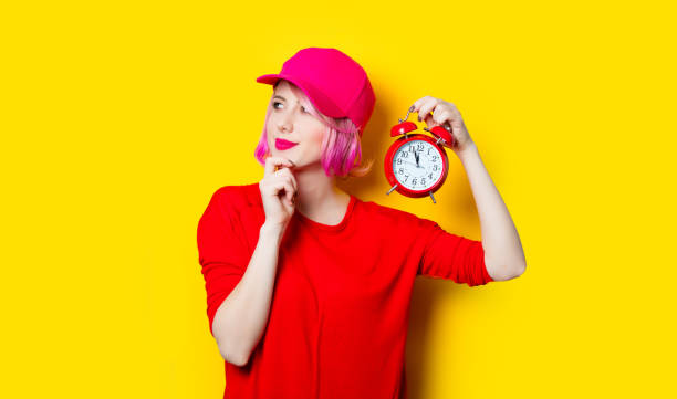 istock young woman with alarm clock 680676660