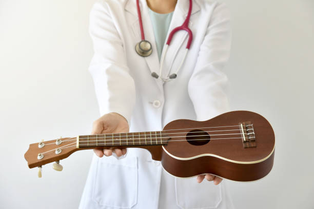 lekarz dając ukulele (instrument muzyczny), koncepcja muzykoterapii. (selektywne ustawianie ostrości) - muzykoterapia zdjęcia i obrazy z banku zdjęć