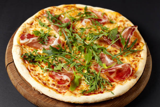 istock Hot pizza Prosciutto on a rustic wooden table. 680683912