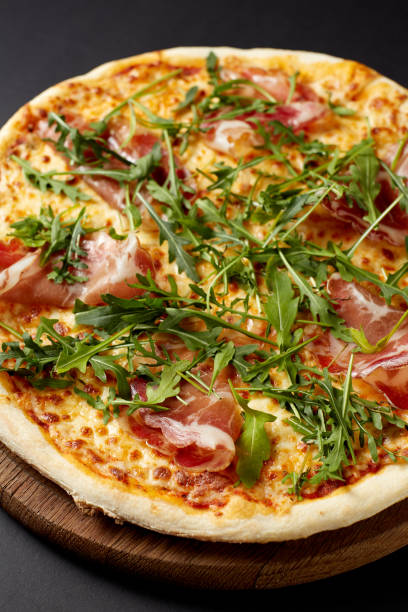 istock Hot pizza Prosciutto on a rustic wooden table. 680683928