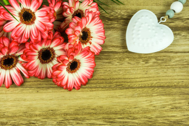 istock Gerbera flowers with a white heart on a rustic wooden background 680691092