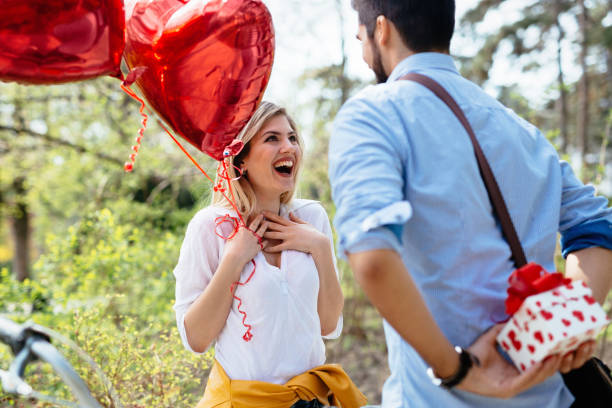 istock Man standing and holding white surprise gift box behind his back 680691726