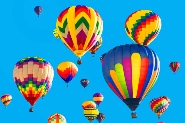Series: Colorful hot air balloons flying in bright blue sky Brightly colored hot air balloons against blue background. Taken with Canon 5D Mark lll. ballooning festival stock pictures, royalty-free photos & images