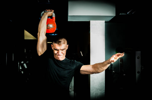 istock Man kettle bell workout in the gym. Kettle bell gym training. 680707396