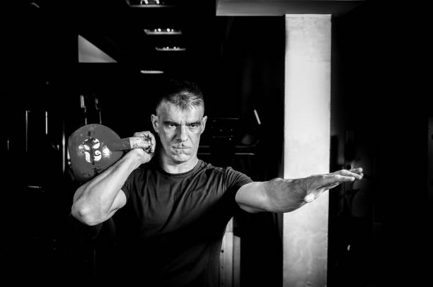 istock Man kettle bell workout in the gym. Black and white. Kettle bell cross training. 680713838
