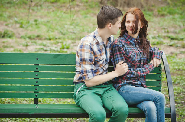 istock Flirting young couple on a bench 680714122