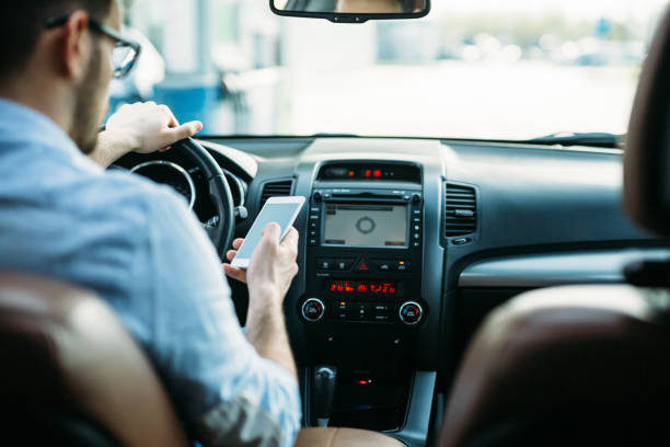 istock Businessman ignoring safety and texting onmobile phone while driving 680714868