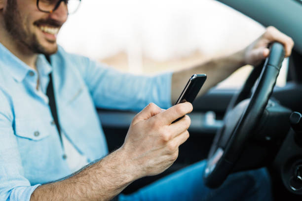 istock Businessman ignoring safety and texting onmobile phone while driving 680714878