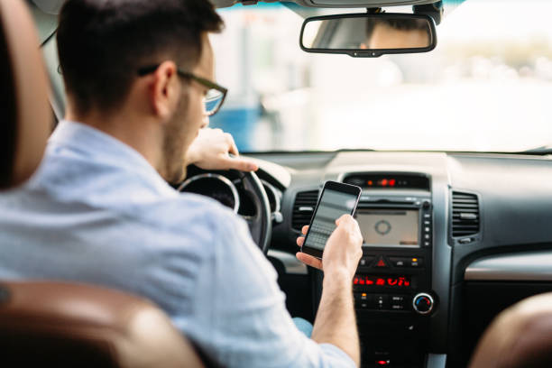 concetto di trasporto - l'uomo che usa il telefono durante la guida dell'auto - driving text messaging accident danger foto e immagini stock