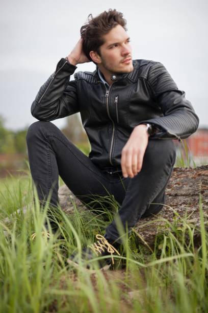 istock Young man in leather jacket sitting on a rock 680717608