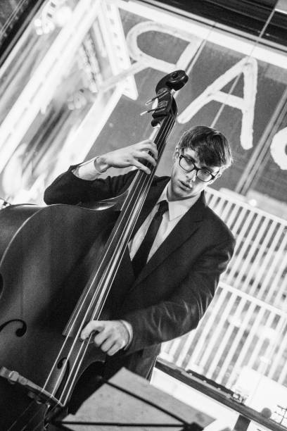 Young man playing contrabasson Young old-fashioned looking man wearing eyeglasses playing bass contra bassoon stock pictures, royalty-free photos & images