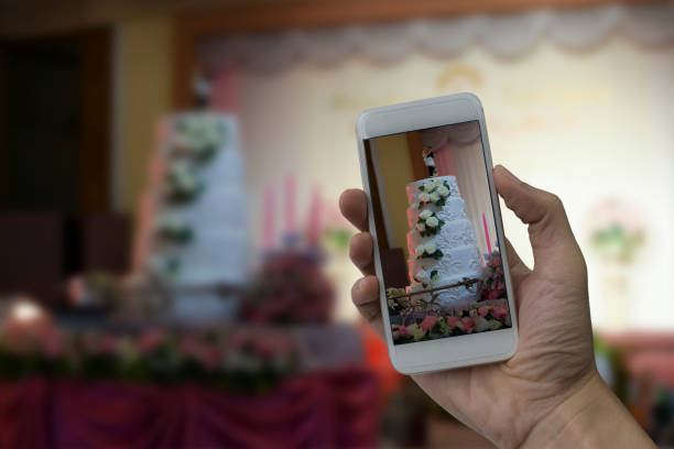 istock Hand holding smart phone take a photo at Wedding hall 680720406