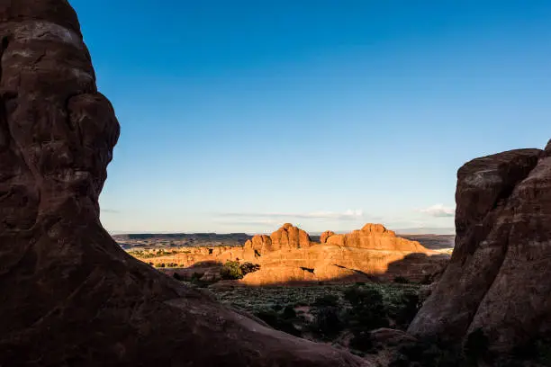 Overlook of red canyons in Arches National Park during sunset