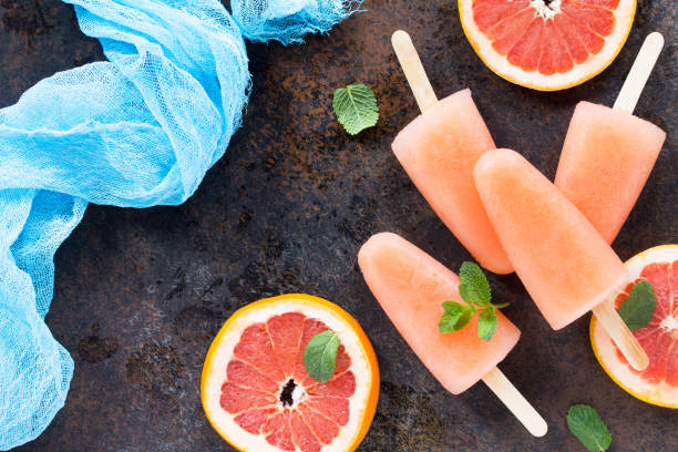 istock Delicious fruit ice grapefruit and ice on a stone background. Place for the text. 680747124