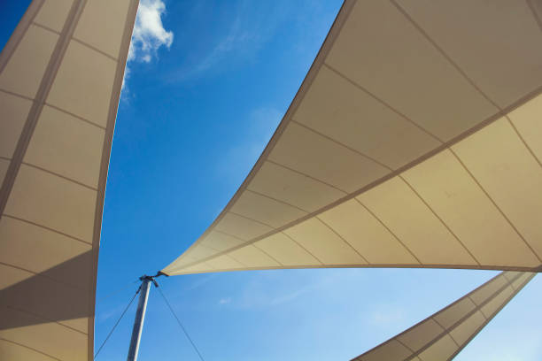 vista inferior del triángulo en forma de sombrillas grandes y claro cielo azul en el fondo en bodrum que es ciudad costera mar egeo de turquía. - toldo estructura de edificio fotografías e imágenes de stock