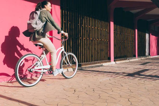 istock Smiling girl on a Bicycle rides along a pink wall 680751948