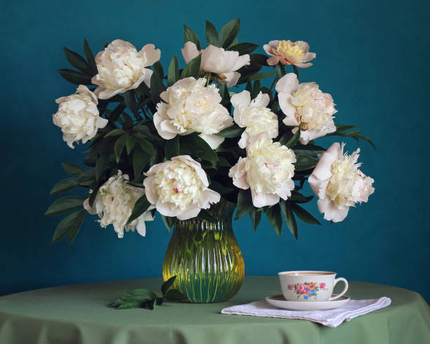 istock Still-life with a bouquet of peonies and cup. 680754464
