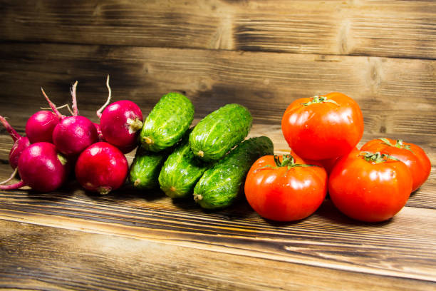 istock Fresh cucumbers, radishes and tomatoes on the wooden table 680779494