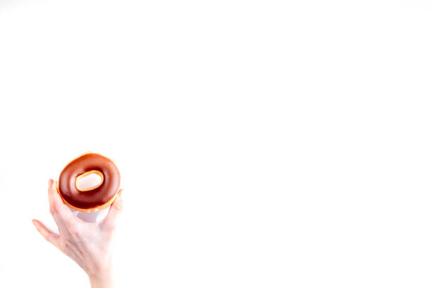 istock chocolate donut in hand on white background top view space for text 680784438