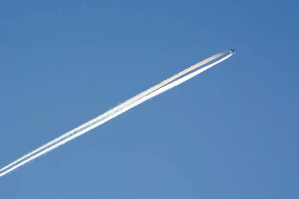 Jet plane trail on clear blue sky.