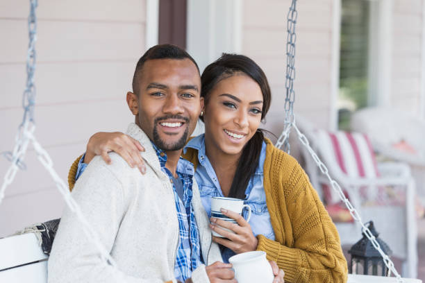 istock Young mixed race couple drinking coffee on porch swing 680789134