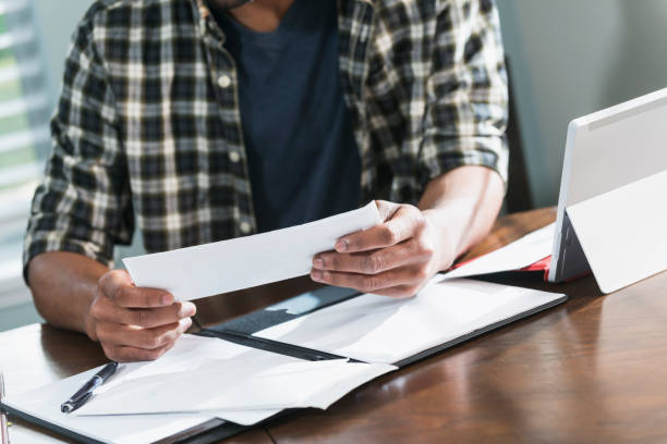 istock Young black man paying bills at home 680789386