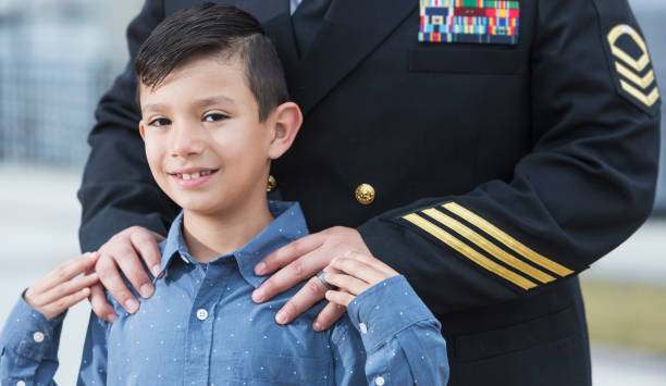 istock Cropped view of navy officer standing behind son 680789444