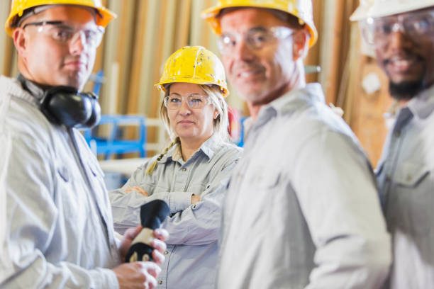 groupe diversifié des travailleurs dans les casques, mettant l’accent sur la femme - minority african ethnicity business hardhat photos et images de collection