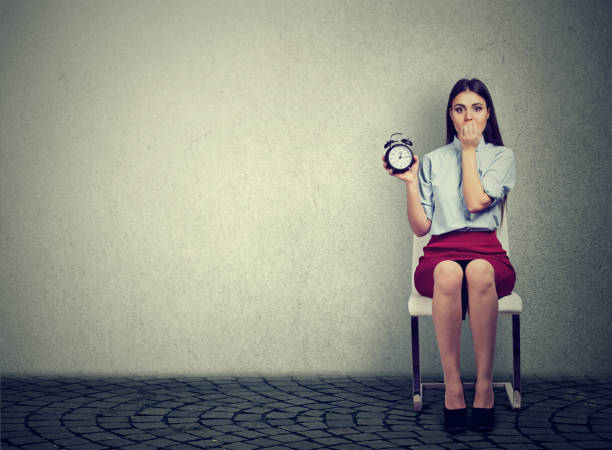 istock Anxious woman with alarm clock waiting for an interview 680793780