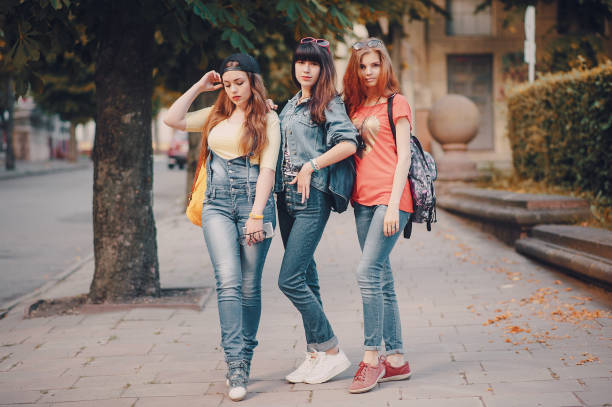 istock three young girls walking in the park 680794732