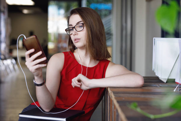 istock Creative Female Student with textbooks listening to music and texting 680794932