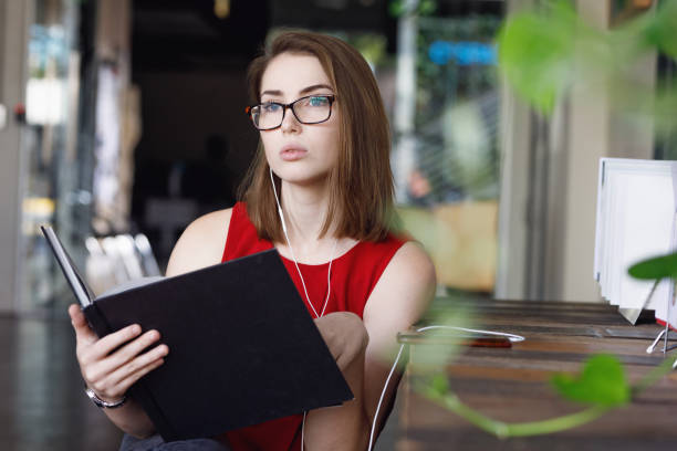 istock Creative Female Student with textbooks listening to music 680794940