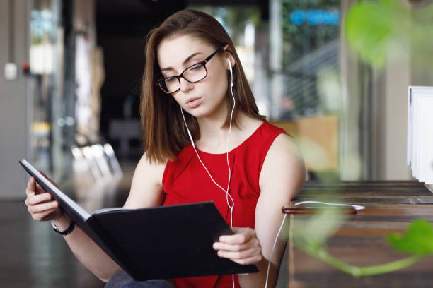 istock Creative Female Student with textbooks listening to music 680794954