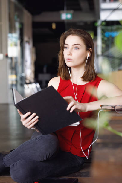 istock Creative Female Student with textbooks listening to music 680794976