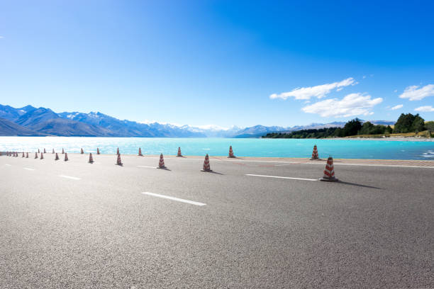 a salmon farm in New Zealand on the South Island. The salmon farm is in the middle of the lake, surrounded by mountains. It is a clear blue sky day.