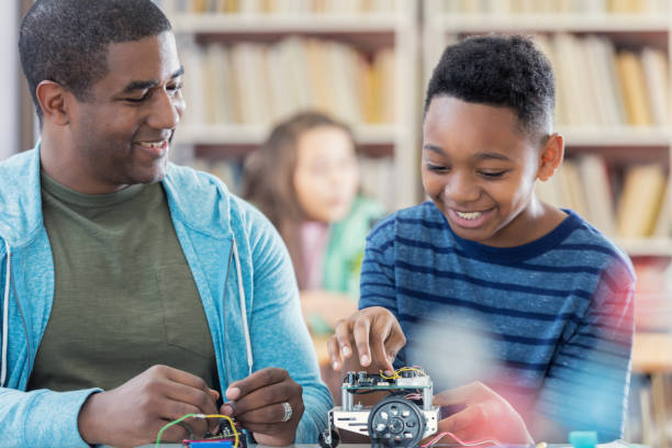 istock Cheerful student builds robotic vehicle in engineering club 680810210