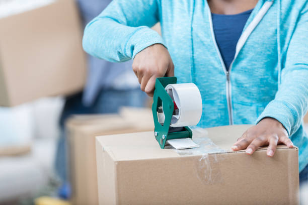 istock Unrecognizable woman tapes moving box 680810280
