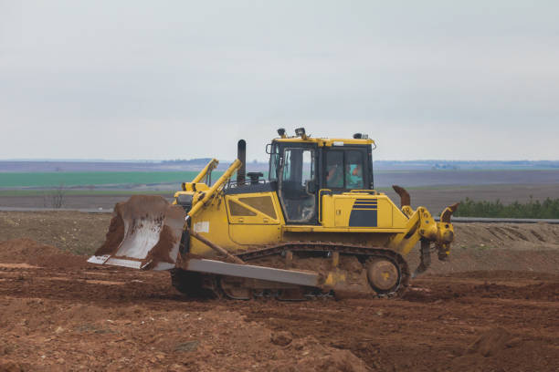istock Yellow excavator on a road construction site among fields 680827670