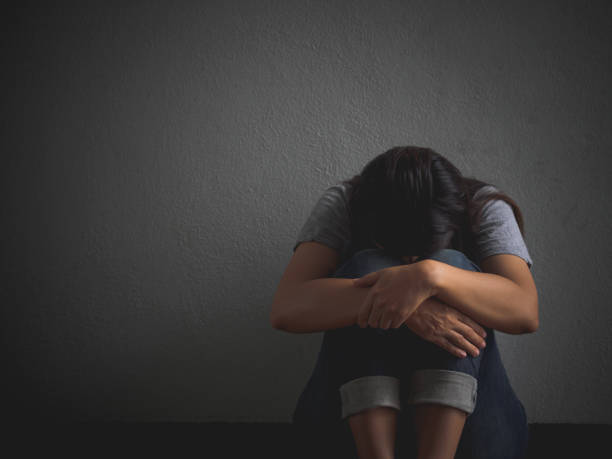 istock sad woman hug her knee and cry. 680829856