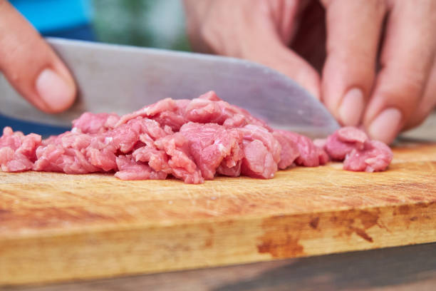 istock Butcher cutting pork meat on kitchen 680833718