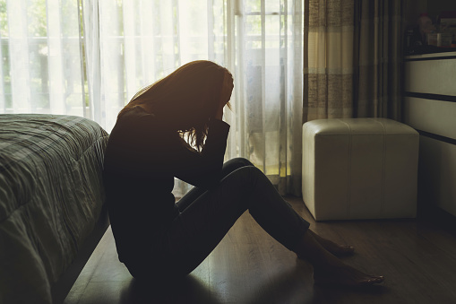 mujer deprimida sentada en el dormitorio oscuro photo