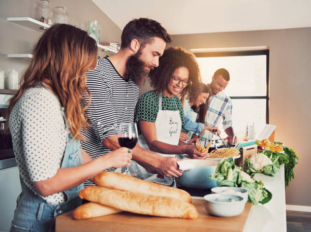 istock Large group of six friends cooking at table 680851364